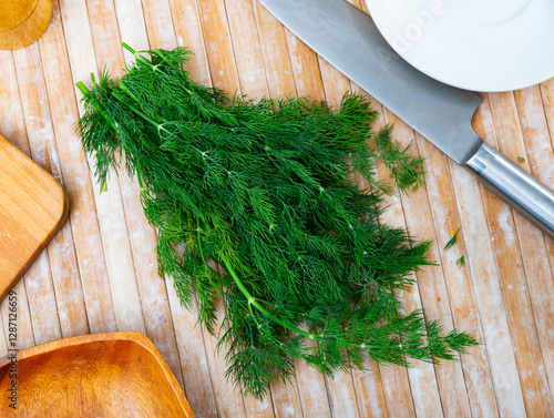 Fresh dill sprigs on kitchen table. Condiment - food ingredient. photo