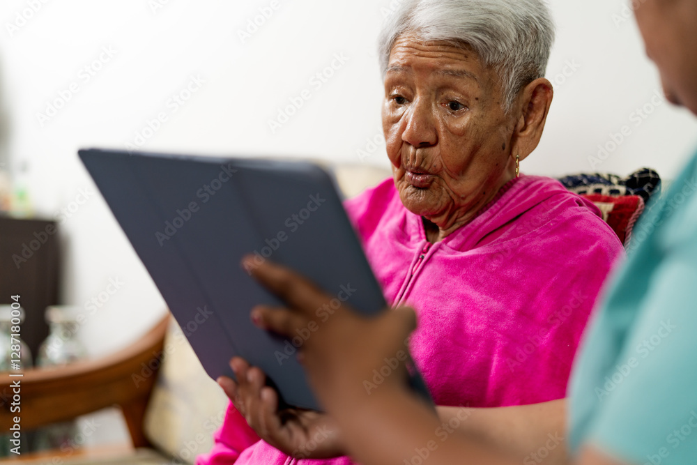 Nurse assisting elderly woman with digital tablet at home Nurse assisting elderly woman with digital tablet at home