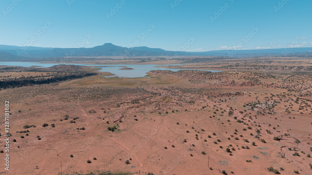 Drone view of a desert environment, mountains and lake in the distance Drone view of a desert environment, mountains and lake in the distance