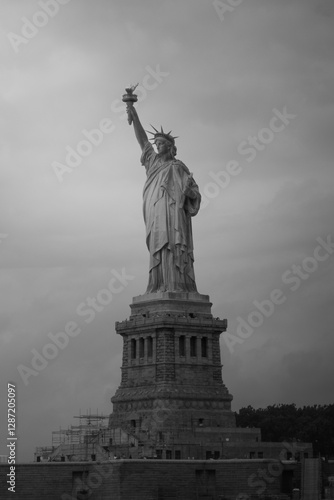 Black and white photo of the Statue of Liberty in New York City, with a cloudy sky in the background.