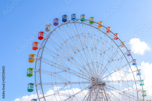 Colourful ferris wheel against a blue sky.