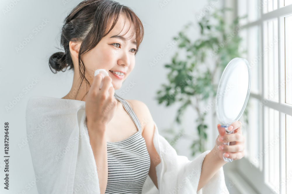 コットンで化粧水を肌につけるアジア人女性
コットンで化粧水を肌につけるアジア人女性