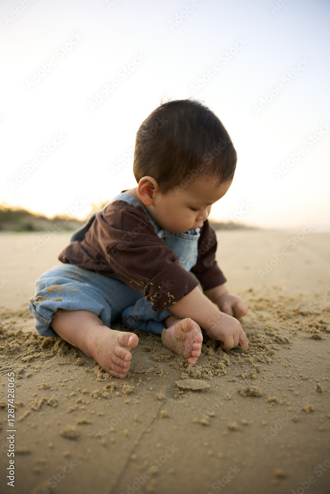 arafed baby boy sitting on the beach playing with sand arafed baby boy sitting on the beach playing with sand
