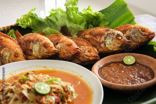 Close up of fried tilapia complete with vegetables and also chili sauce and raw vegetable salad, Indonesian food, Asian food