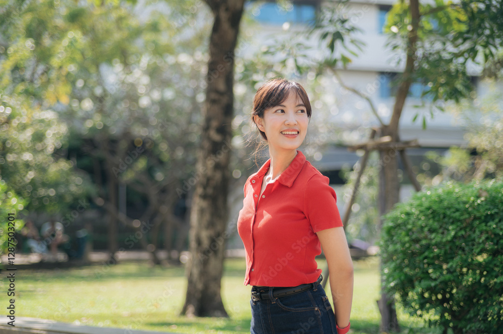 Asian cheerful woman in red shirt enjoys sunny day in green park, surrounded by trees and natural light Asian cheerful woman in red shirt enjoys sunny day in green park, surrounded by trees and natural light