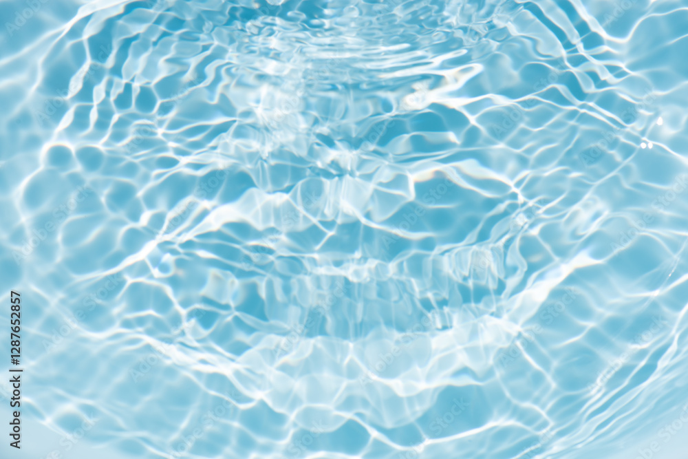 Obraz premium Blue water with ripples on the surface. Defocus blurred transparent blue colored clear calm water surface texture with splashes and bubbles. Water waves with shining pattern texture background.