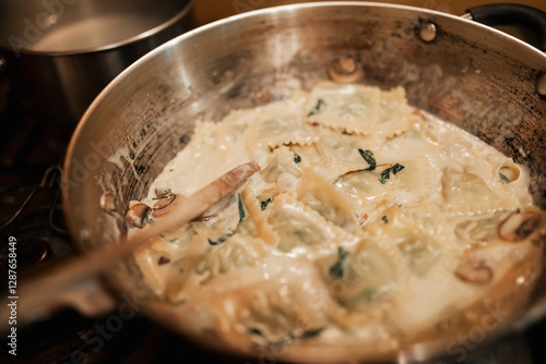 Tortellini pasta dish with creamy white sauce simmering in pan ready to serve