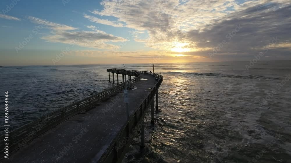 Drone scenery of Abandoned Pier over ocean waves and an egret flew in front of the camera at sunset Drone scenery of Abandoned Pier over ocean waves and an egret flew in front of the camera at sunset