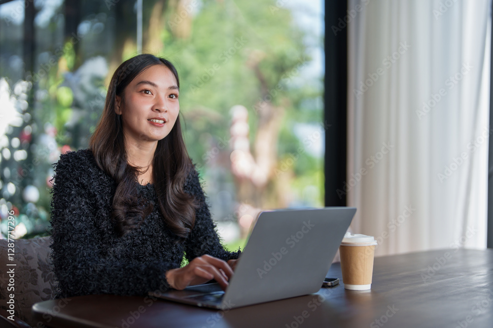 Young asian businesswoman using laptop computer while sitting in cafe, enjoying takeaway coffee during a break, working remotely or studying online Young asian businesswoman using laptop computer while sitting in cafe, enjoying takeaway coffee during a break, working remotely or studying online