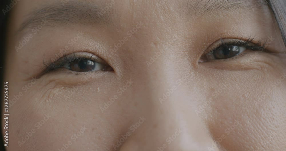 Close-up slow motion of happy Asian woman's eyes looking at camera smiling expressing joy. People and positive emotion concept. Close-up slow motion of happy Asian woman's eyes looking at camera smiling expressing joy. People and positive emotion concept.