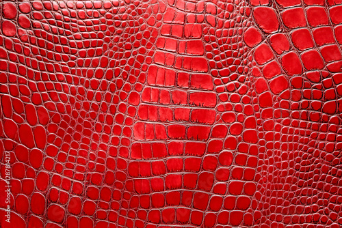 A close-up of vibrant red crocodile leather, showcasing its unique scales and texture, perfect for fashion and luxury design themes