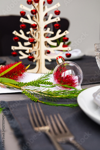 Australian christmas theme table with red native bottlebrush flower, with small christmas tree photo