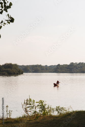 Person kayaking on a tranquil lake