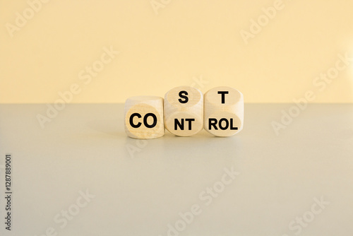 Cost control symbol. Turned wooden cubes and changes the concept word Cost to Control. Beautiful gray table beige background. Business cost control concept.