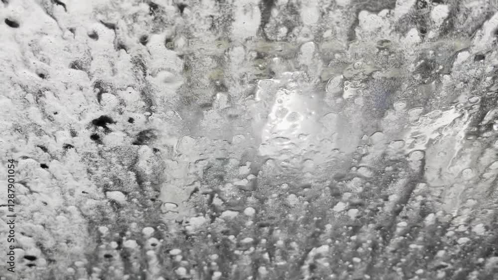 foam is running down the front window of a car, view from the driver seat in automatic car wash. Reset concept foam is running down the front window of a car, view from the driver seat in automatic car wash. Reset concept