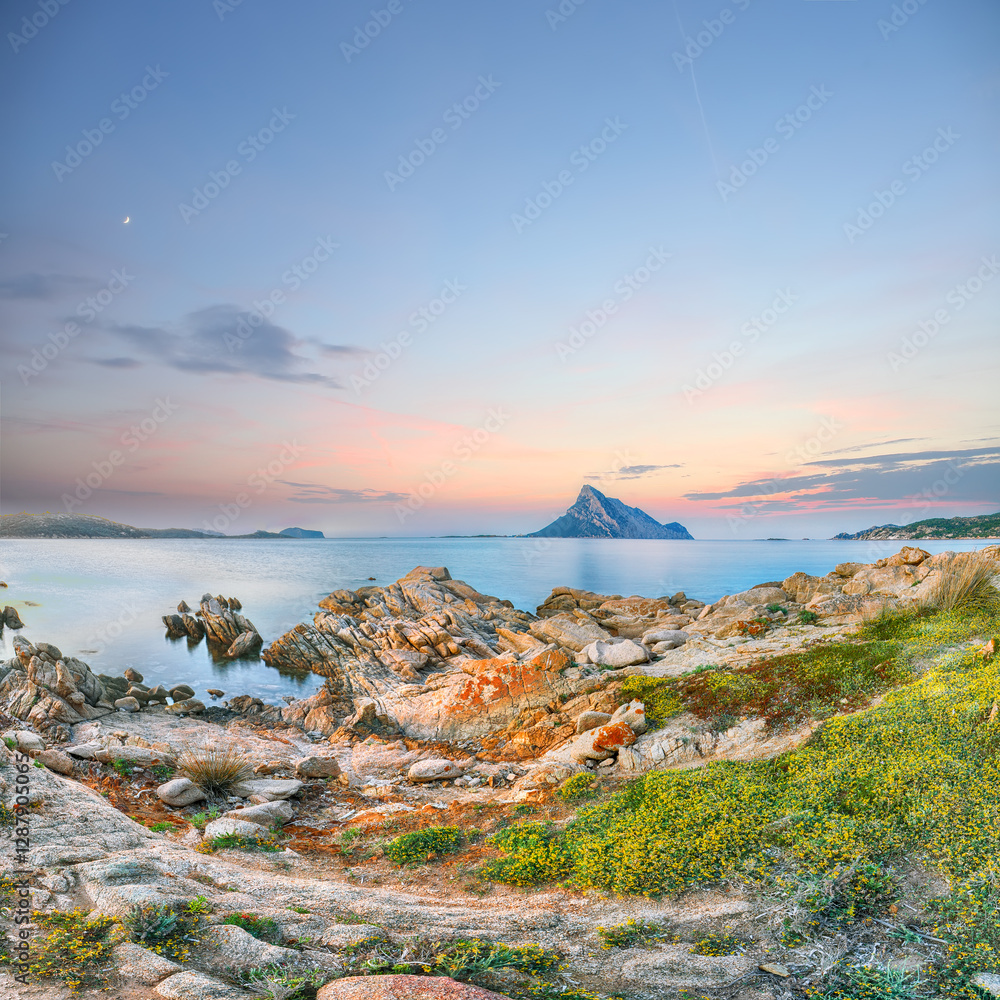 Superb evening scene of Porto Taverna beach with Tavolara mountain on background.