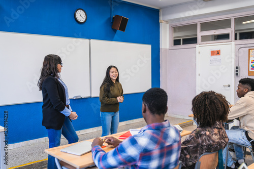 High school student giving presentation to classmates and teacher