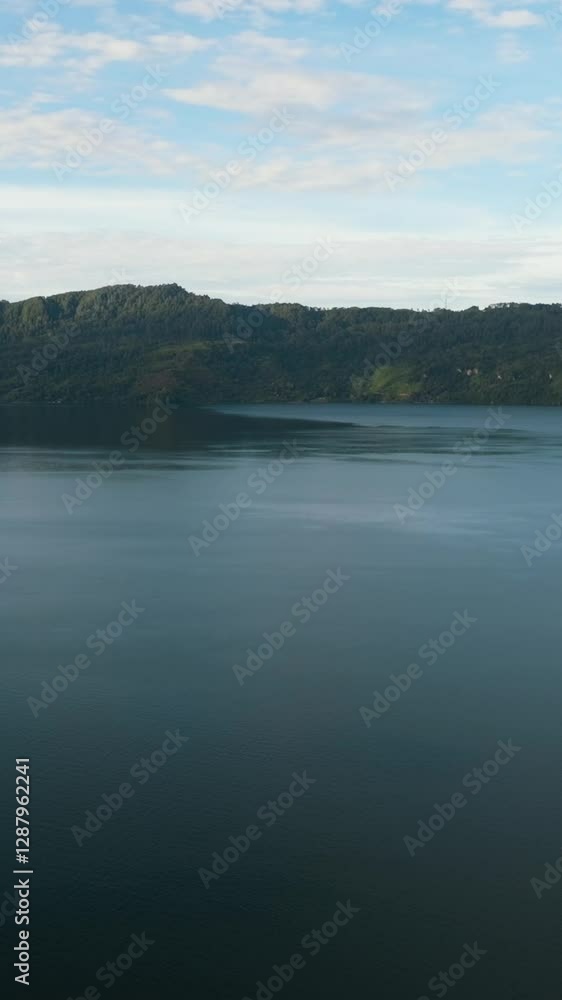 Top view of lake Toba among the mountains with rainforest. Sumatra, Indonesia. Vertical video. Top view of lake Toba among the mountains with rainforest. Sumatra, Indonesia. Vertical video.