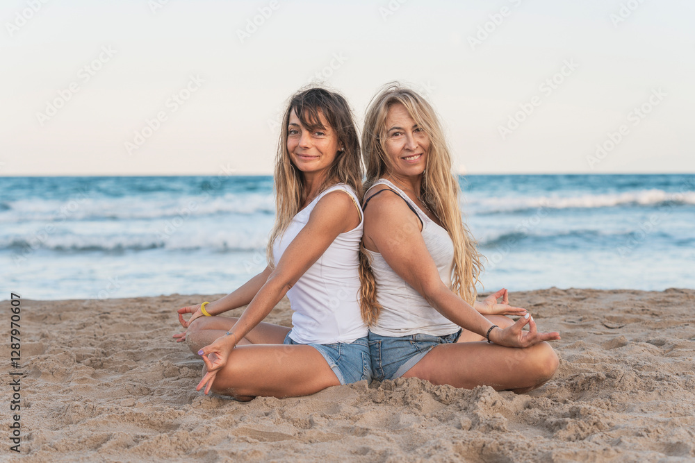 Two women praticing Acro Yoga on the beach Two women praticing Acro Yoga on the beach