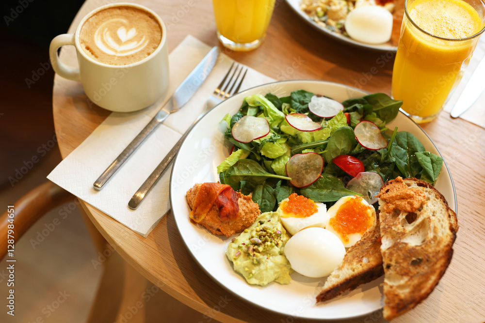 Tasty breakfast. Salad and eggs with red caviar served on wooden table in cafe, closeup Tasty breakfast. Salad and eggs with red caviar served on wooden table in cafe, closeup