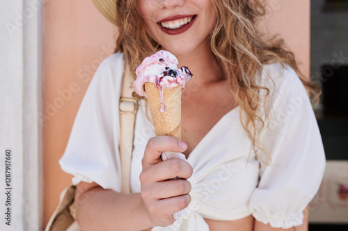 Close-up of young woman holding melting eating ice cream cone in summer photo