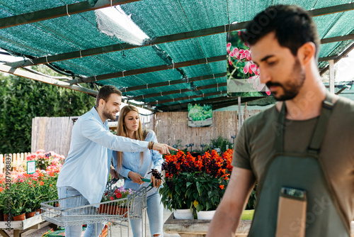 Couple buying flowers in a garden center photo