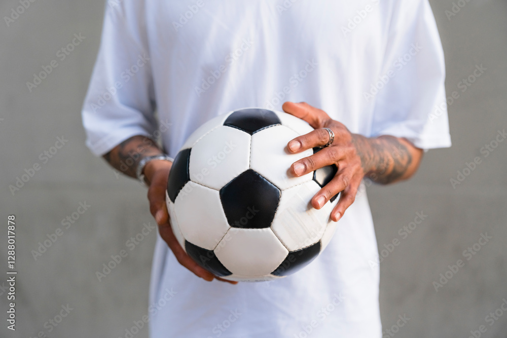 Young man's hands holding football, close-up Young man's hands holding football, close-up
