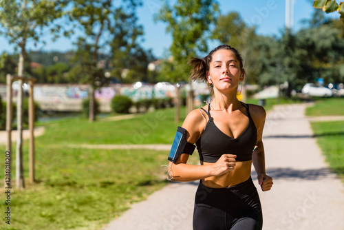 Portrait of young woman running in a park photo