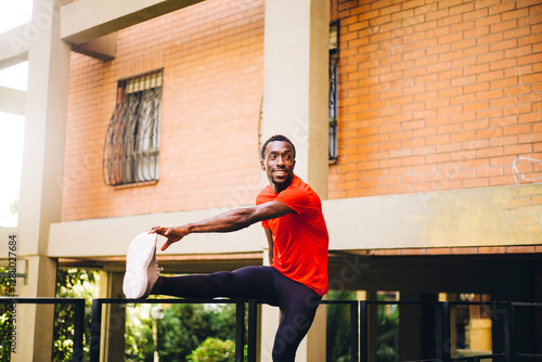 Young sportive man doing stretching exercise outdoors
