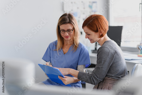 Female doctor consulting with a female patient, discussing test result in doctor office.