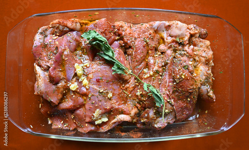 Obraz na płótnie Marinated meat with herbs and spices in a glass dish ready for cooking at a kitchen counter w salonie
