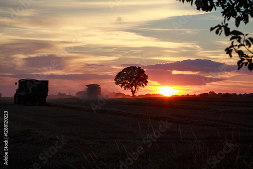 combine harvester at sunset