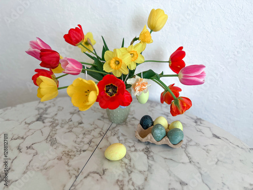 Obraz na płótnie An Easter card. Colorful bright tulips decorated with eggs stand in a vase on the table next to colorful eggs w salonie