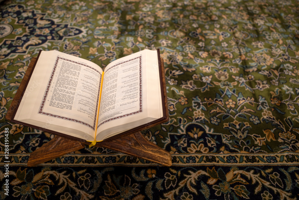 Obraz premium An opened holy book of the Quran on a green carpet at the Prophet Mosque, Masjid Nabawi in the city of Medina, Saudi Arabia