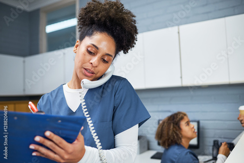 Female Healthcare Worker Taking Notes While Using a Phone in a Modern Medical Office