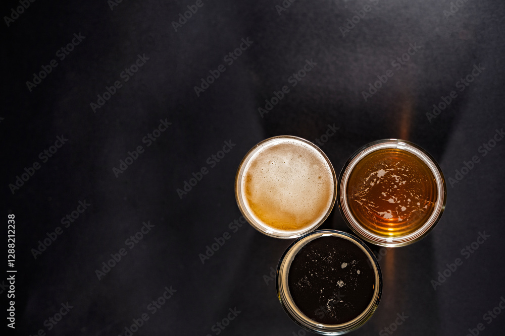 Three glasses of beer in the right left corner with empty space on the left, top view