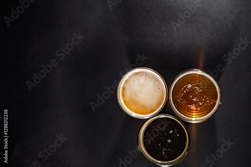 Obraz na płótnie Three glasses of beer in the right left corner with empty space on the left, top view w salonie