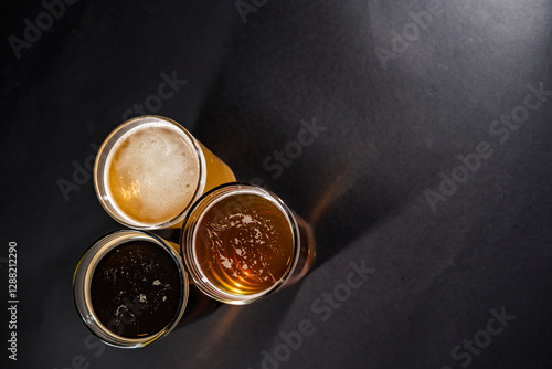 Obraz na płótnie Three glasses of beer in the lower left corner with empty space on the right, top view w salonie