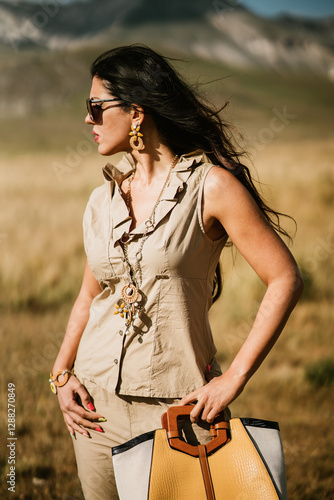 close up view of beautiful woman in dress holding necklace and bijoux