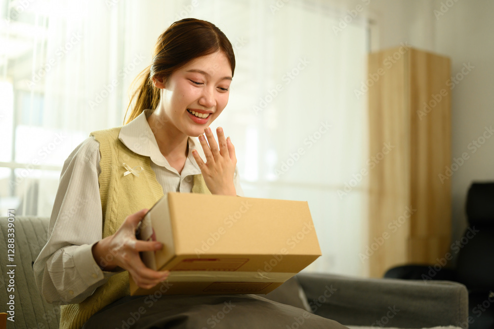 A delighted young woman excitedly receives a package, revealing the thrill of online shopping and home delivery A delighted young woman excitedly receives a package, revealing the thrill of online shopping and home delivery