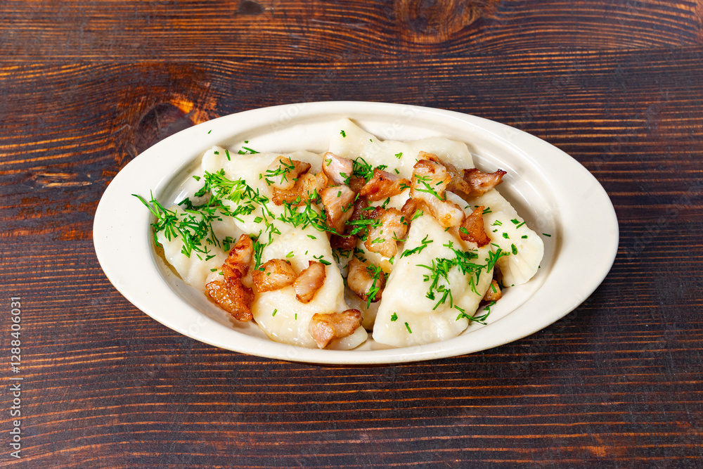Delicious dumplings topped with crispy bacon on a wooden table