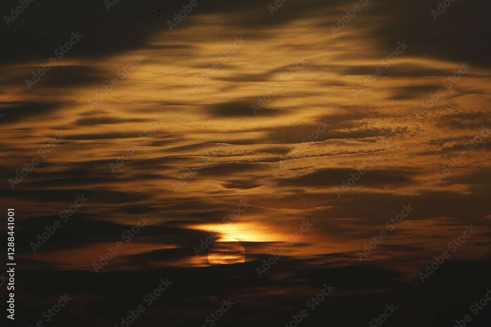 Obraz premium a sunset seen in the sky over a rice field in nakhon sawan province, north of bangkok on february 23, 2025..