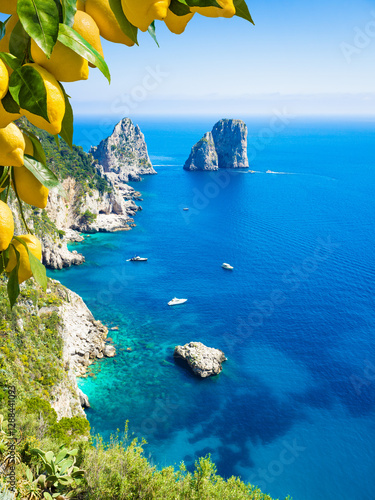 Capri, Italy, with iconic Faraglioni rocks and turquoise waters of Mediterranean sea. Bright yellow lemons in foreground add vibrant contrast to deep blue sea. Welcome to Capri!
