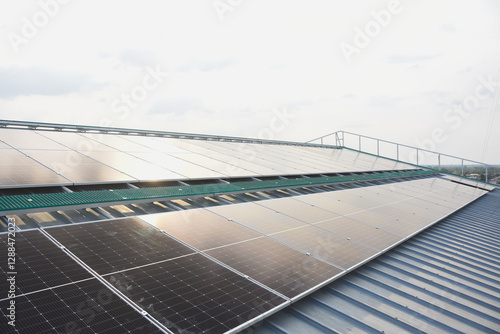 large array of solar panels installed on a rooftop. The solar panels are arranged in rows and are angled to maximize exposure to sunlight. photo