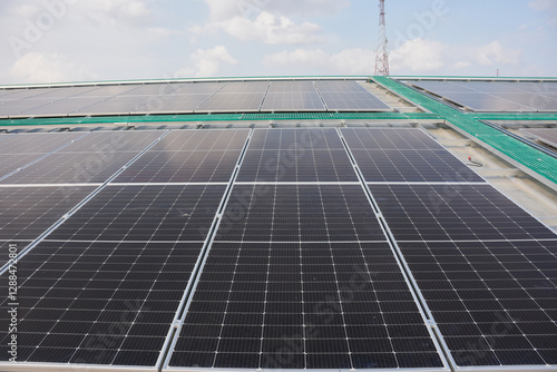 large array of solar panels installed on a rooftop. The solar panels are arranged in rows and are angled to maximize exposure to sunlight. photo