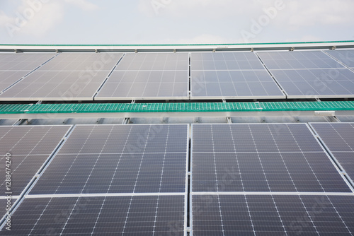 large array of solar panels installed on a rooftop. The solar panels are arranged in rows and are angled to maximize exposure to sunlight. photo