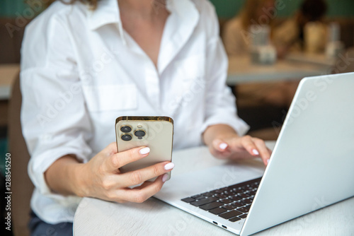 Business woman using mobile smart phone and online working on laptop computer, surfing the internet, searching the information at office. Female student online studying from home, e-learning concept