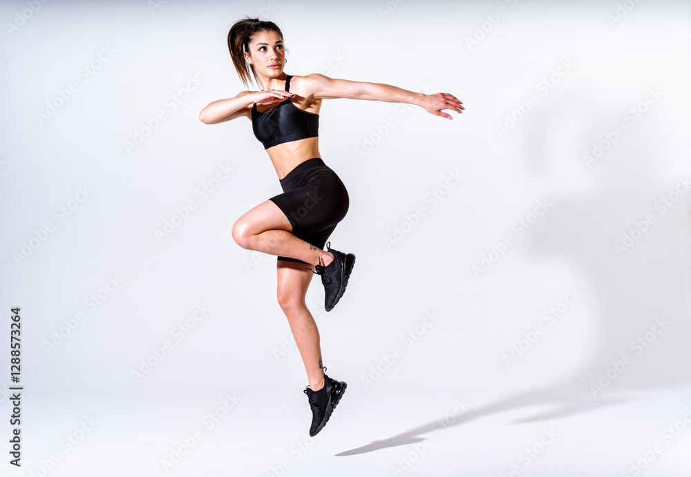 Young female athlete training in a gym using sport equipment Young female athlete training in a gym using sport equipment