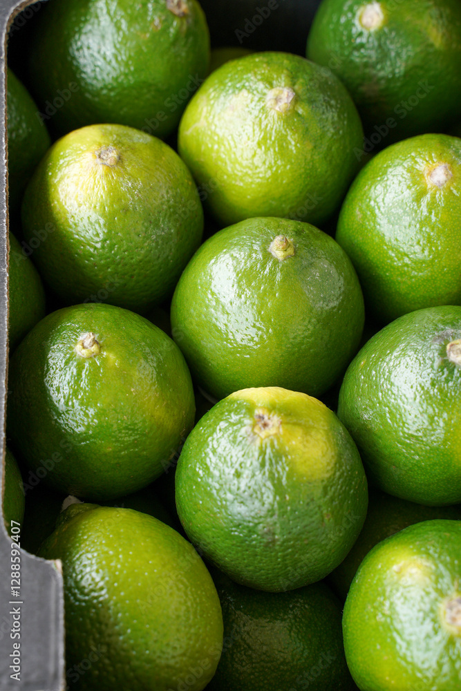 Green lime. Selective focus. Fresh ripe juicy limes as a food background or texture. Green lemon fruits in a box. Green lime. Selective focus. Fresh ripe juicy limes as a food background or texture. Green lemon fruits in a box.