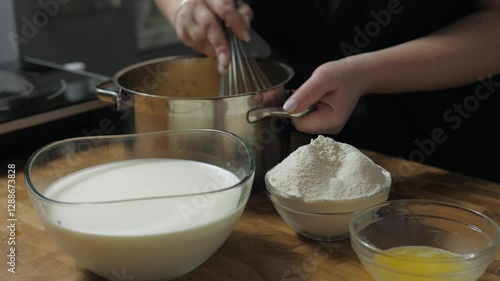 Whisking egg with a metal wire whisk. Female pastry chef preparing dough 